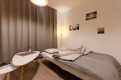 a bedroom with a bed with a desk and a table at White Swan Apartment in Kraków