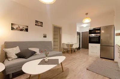 a living room with a couch and a table at White Swan Apartment in Kraków