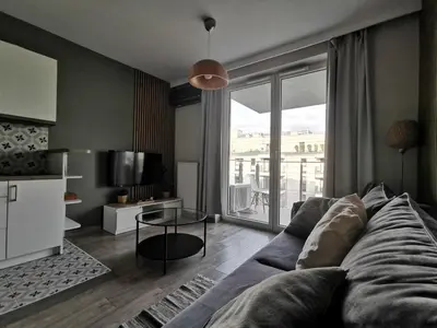 a living room with a couch and a large window at White Swan Apartment in Kraków