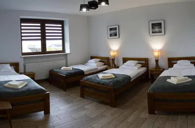 a room with two beds and a couch and a window at Leo House in Gaj