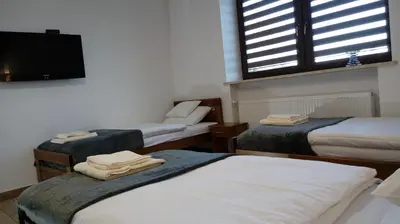 a room with three beds and a window at Leo House in Gaj