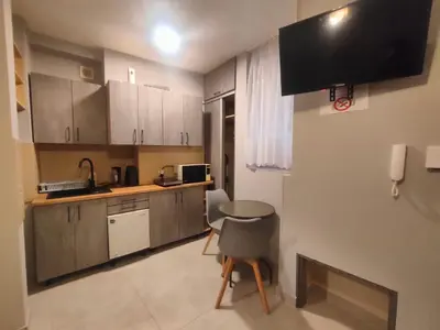 a small kitchen with a table and a sink at Apartamenty Amber in Kraków