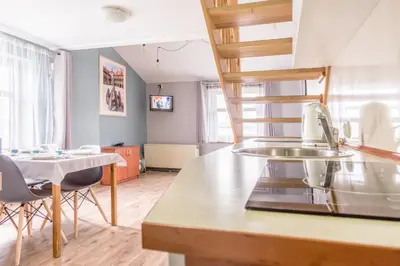 a kitchen with a sink and a table with chairs at Apartamenty Amber in Kraków