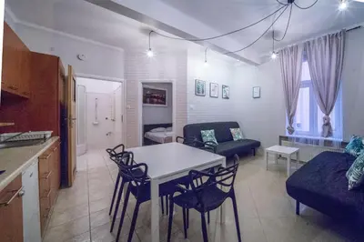 a kitchen and living room with a table and chairs at Apartamenty Amber in Kraków