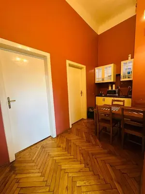 a kitchen with orange walls and a white door at Main Market Square Apartments in Kraków