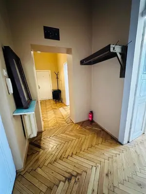 an empty room with a wooden floor and a television at Main Market Square Apartments in Kraków