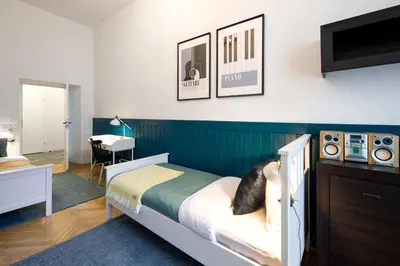 a bedroom with a bed with a blue wall at WAWELOVE spacious 3 bedroom apt 1 min to Main Sq! in Kraków