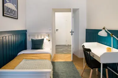 a bedroom with a bed and a desk and a desk at WAWELOVE spacious 3 bedroom apt 1 min to Main Sq! in Kraków