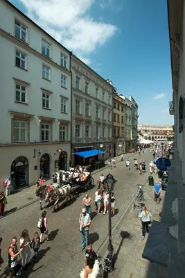 a group of people sitting on a street with buildings at WAWELOVE spacious 3 bedroom apt 1 min to Main Sq! in Kraków