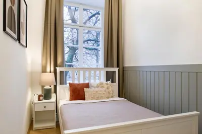 a bedroom with a white bed with a window at WAWELOVE spacious 3 bedroom apt 1 min to Main Sq! in Kraków