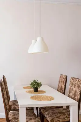 a white dining room table with chairs and a potted plant at Floriańska Glamour Apartments in Kraków