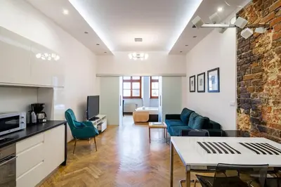 a kitchen and living room with a couch and a table at Floriańska Glamour Apartments in Kraków