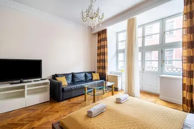 a living room with a couch and a television at Floriańska Glamour Apartments in Kraków