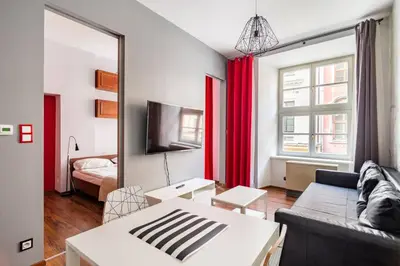 a living room with a couch and a mirror at Floriańska Glamour Apartments in Kraków