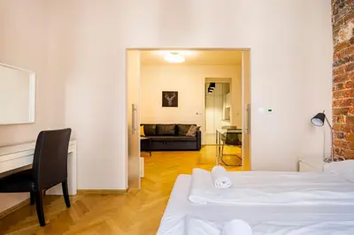 a room with two beds and a desk and a couch at Floriańska Glamour Apartments in Kraków