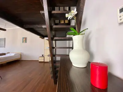 a white vase sitting on a table in a living room at P&J Apartamenty Grodzka in Kraków