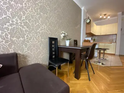 a living room with a table and chairs and a kitchen at P&J Apartamenty Grodzka in Kraków