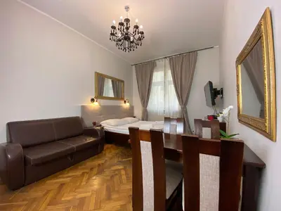 a living room with a couch and a dining room table at P&J Apartamenty Św. Krzyża in Kraków