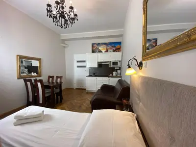 a hotel room with a bed and a living room at P&J Apartamenty Św. Krzyża in Kraków