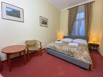 a bedroom with a bed and a desk and a table at P&J Apartamenty Św. Krzyża in Kraków