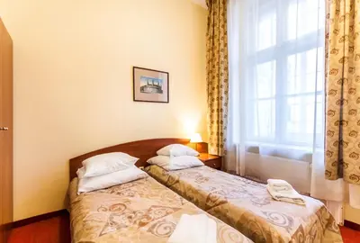 two beds in a room with a window at P&J Apartamenty Św. Krzyża in Kraków