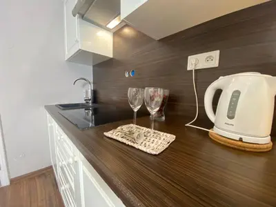 a kitchen counter with a toaster and wine glasses on it at P&J Apartamenty Św. Krzyża in Kraków