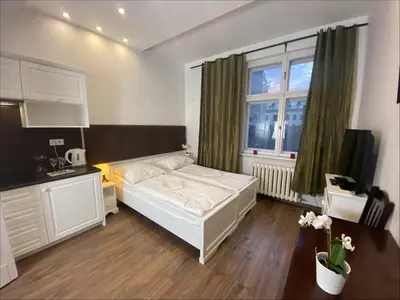 a bedroom with a white bed and a window at P&J Apartamenty Św. Krzyża in Kraków