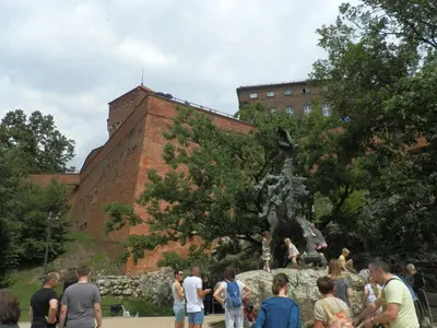 a group of people standing around a statue in front of a building at AP Na Groblach in Kraków