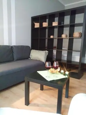 a living room with a couch and two glasses of wine at AP Na Groblach in Kraków