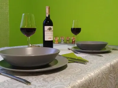 a table with two bowls and a bottle of wine at AP Na Groblach in Kraków