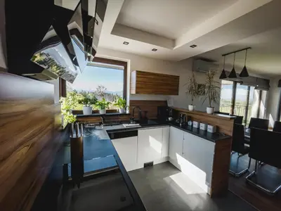 a kitchen with white cabinets and a large window at Apartament Blisko Słońca - Jacuzzi na wyłączność in Nowy Targ