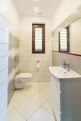 a white bathroom with a toilet and a sink at Apartament Blisko Słońca - Jacuzzi na wyłączność in Nowy Targ