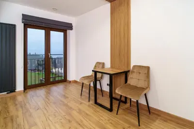 a room with a table and two chairs and a window at Apartament Blisko Słońca - Jacuzzi na wyłączność in Nowy Targ