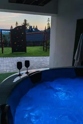 a large blue pool with two wine glasses in it at Apartament Blisko Słońca - Jacuzzi na wyłączność in Nowy Targ