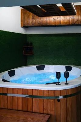 a jacuzzi tub with two wine glasses on it at Apartament Blisko Słońca - Jacuzzi na wyłączność in Nowy Targ