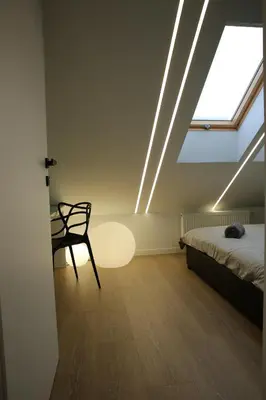 a room with a bed and a chair and a window at Apartamenty Premium Wadowice in Wadowice