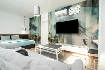 a room with two beds and a tv on a wall at Apartamenty Premium Wadowice in Wadowice