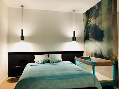 a bedroom with a bed with two lights above it at Apartamenty Premium Wadowice in Wadowice