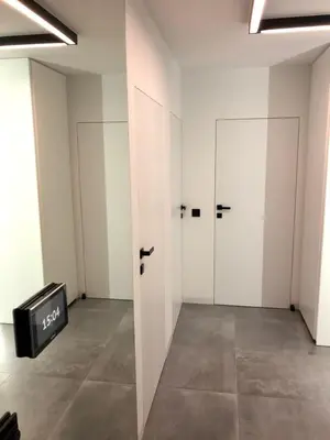 an empty room with two white doors and a tv at Apartamenty Premium Wadowice in Wadowice