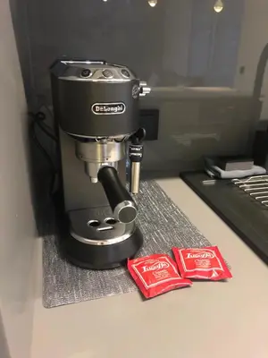 a coffee maker sitting on a counter with two packets of coke at Apartamenty Premium Wadowice in Wadowice