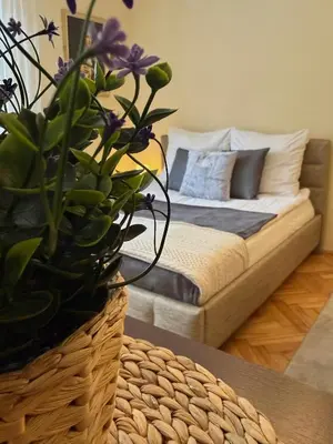 a table with a plate of fruit and a vase with flowers at Apartament u Janka in Wieliczka