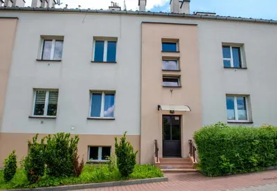 an apartment building with a front door and bushes at Apartament u Janka in Wieliczka