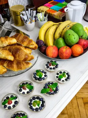 a table topped with lots of different types of bread and fruit at Kosmopolita Apartments in Kraków