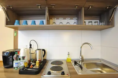 a kitchen counter with a sink and a stove at Kosmopolita Apartments in Kraków