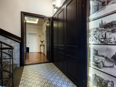 a hallway with black doors and a tile floor at Kosmopolita Apartments in Kraków