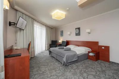 a hotel room with a bed and a desk at Hotel Badura in Wadowice