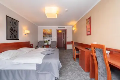 a hotel room with a bed and a desk at Hotel Badura in Wadowice