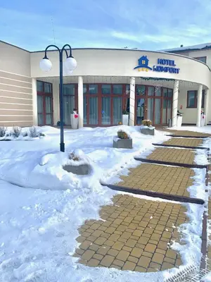 a building with a street light in the snow at Hotel Komfort in Krzywaczka