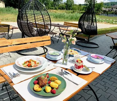 a wooden table with plates of food on it at Hotel Komfort in Krzywaczka