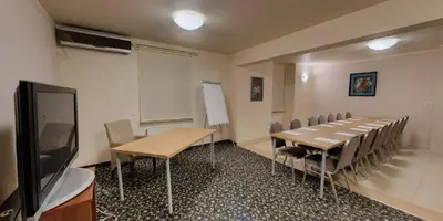 a conference room with a table and chairs and a tv at Hotel Komfort in Krzywaczka